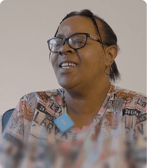 Lechane, wearing glasses, smiling during an interview